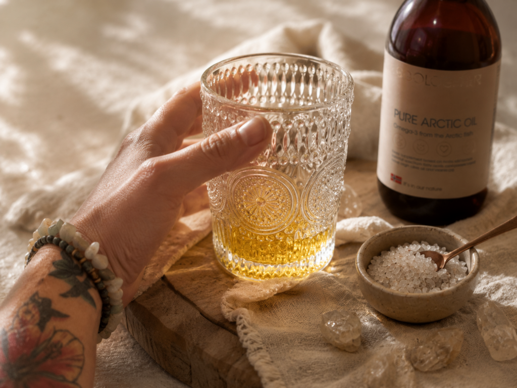 Glas met goudgele omega 3-olie en de fles op de achtergrond